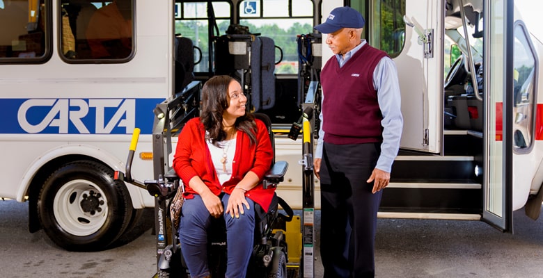 a CARTA employee helping a disabled person